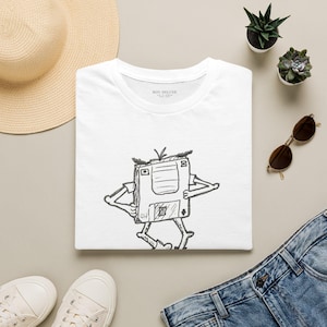 Op de afbeelding: Een wit T-shirt met korte mouwen en een zwarte inkttekening van een diskette-personage met armen en benen. Het shirt heeft een ronde hals en de tekst BON DELUXE is gedrukt aan de binnenkant van de kraag bij de nek.