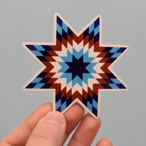 May include: A white star-shaped sticker with a geometric pattern in shades of blue, red, and white.