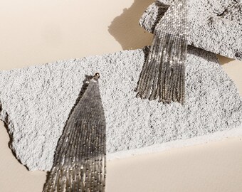 Pendientes con flecos y cuentas brillantes: joyas llamativas en gris y plata