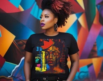 May include: Black t-shirt featuring a colorful abstract portrait with a red arrow and the text "What I do is my business." The artwork includes shades of blue, yellow, and red. The background is a vibrant graffiti wall.