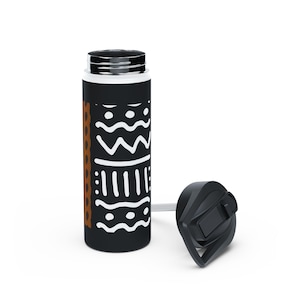 May include: Black water bottle with a white tribal pattern and a brown vertical stripe. The bottle has a black lid and a straw. The bottle is cylindrical and appears to be made of metal.
