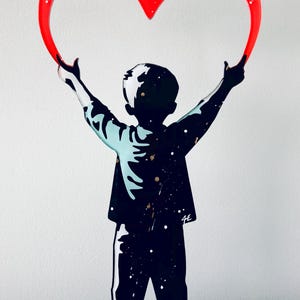 Puede incluir: Una silueta negra de una persona sosteniendo un gran corazón rojo sobre su cabeza. La persona está de pie sobre una base de acrílico transparente. El corazón está hecho de acrílico y tiene un acabado brillante.