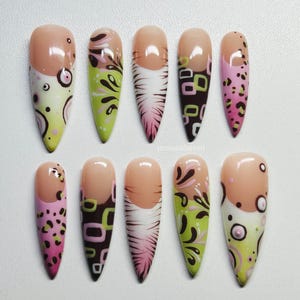 Puede incluir: Un conjunto de diez u&ntilde;as postizas con varios dise&ntilde;os. Cada u&ntilde;a presenta una base de color nude con diferentes patrones, incluyendo estampado de leopardo rosa, formas geom&eacute;tricas verdes y marrones y dise&ntilde;os florales abstractos. Las u&ntilde;as son almendradas.