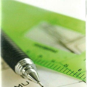 Può includere: Primo piano di una matita meccanica con impugnatura nera e dettagli argentati su un foglio di carta. Un righello verde sullo sfondo. Il testo "AutoSketch 10" è in alto. La carta ha le lettere "CMU" e "MU" scritte.