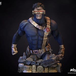 May include: A bust of Cyclops from X-Men, in a dynamic pose. The figure is predominantly blue with gold accents, including a belt and visor. The base is a rocky, textured surface. The X-Men and Wicked logos are visible.