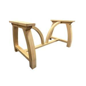 May include: A wooden table base with a curved design. The base is made of unfinished wood and has a natural color.