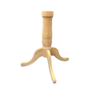 May include: A light-colored wooden table base with a three-legged design. The base has a central column with a cylindrical top and a decorative, turned design. The legs curve outward, providing stability. The wood has a natural finish.