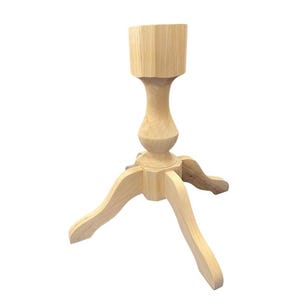 May include: A wooden pedestal stand with a three-legged base and a decorative, turned column. The top is octagonal. The stand is unfinished and ready for paint or stain.