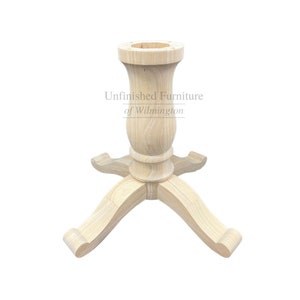 May include: Unfinished wood table base with a turned pedestal and four curved legs. The base is designed for a round table top.