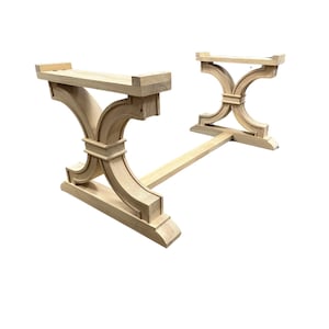 May include: Unfinished wood table base with a simple, elegant design. The base features two curved supports connected by a straight beam.