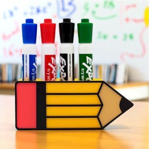 May include: A pencil-shaped desk organizer holds four dry-erase markers. The markers have blue, red, black, and green caps. The organizer is yellow with a red eraser and a tan pencil tip.