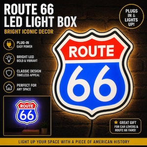 May include: A Route 66 LED light box in the shape of the iconic road sign. The sign features a red top, blue center with white "66" numerals, and a white border. The sign is illuminated and plugs into a power outlet.