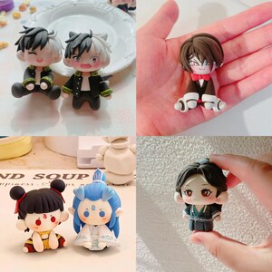 May include: A selection of handmade anime-style figurines. The figures display intricate designs, including characters with black and white hair, and others with detailed costumes. The figures are in different poses, highlighting their unique features and expressions.