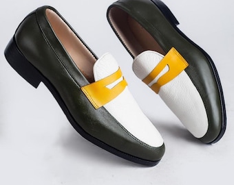 May include: A pair of green and white leather loafers with a yellow leather accent. The loafers have a pointed toe and a low heel.