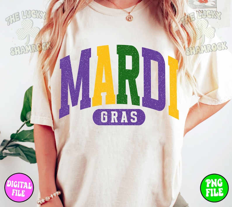 Puede incluir: Una camiseta blanca con un gr&aacute;fico morado, verde y amarillo que dice "Mardi Gras".