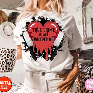 May include: White t-shirt with a red dripping heart that says "True Crime is my Valentine" with two black knives on either side of the heart.
