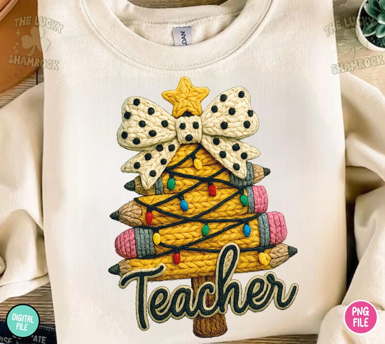 May include: Cream-colored sweatshirt featuring a Christmas tree design made of pencils, a bow, and a star. The pencils are yellow with pink erasers and are decorated with colorful lights. The word "Teacher" is written in a script font.