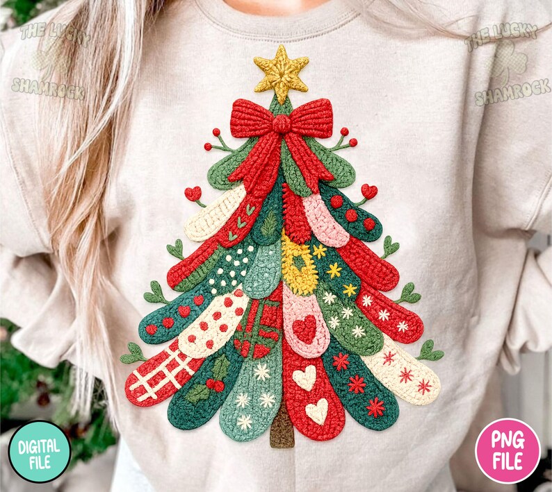 May include: A beige sweatshirt featuring a colorful Christmas tree design. The tree is composed of various knitted elements in red, green, and other colors, adorned with hearts, stars, and bows. A yellow star tops the tree.