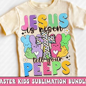 Puede incluir: Una camiseta crema para ni&ntilde;os con la frase "JESUS is risen tell your PEEPS" en letras de burbujas coloridas. El dise&ntilde;o incluye gr&aacute;ficos de conejitos de Pascua y una cruz con estampado de leopardo. Las palabras "EASTER KIDS SUBLIMATION BUNDLE" est&aacute;n en la parte inferior.