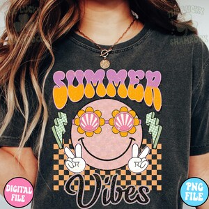 May include: A black t-shirt with a graphic design featuring a smiling face with sunglasses, peace signs, and the text "Summer Vibes" in a retro font.