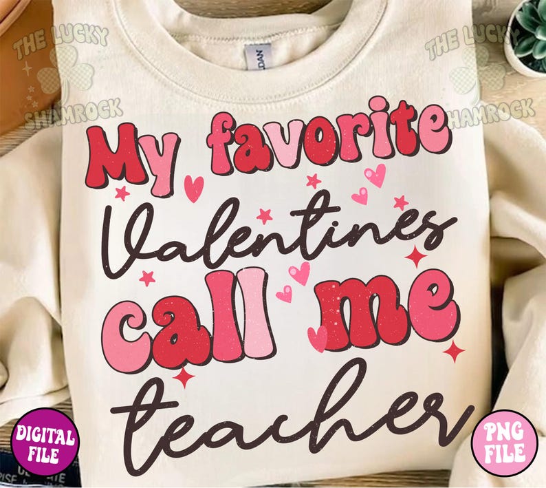 May include: A white sweatshirt with the text "My favorite Valentines call me teacher" in pink and red letters with a distressed look. The text is surrounded by small hearts and stars.