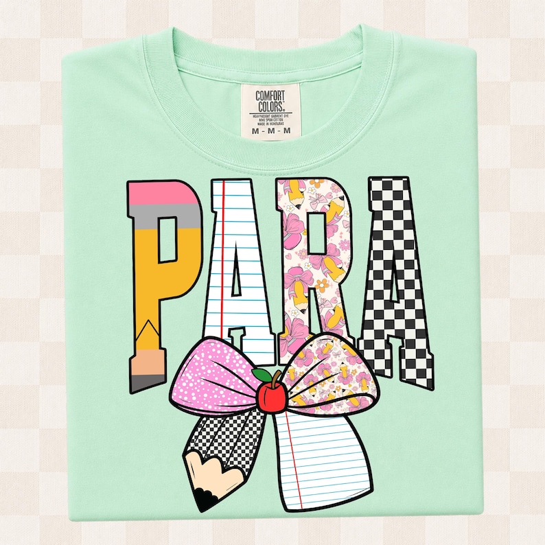 K&ouml;nnte beinhalten: Ein helles mintgr&uuml;nes T-Shirt mit dem Wort PARA in gro&szlig;en Blockbuchstaben. Jeder Buchstabe hat ein einzigartiges Muster: Bleistift, liniertes Papier, Blumenmuster und schwarz-wei&szlig;es Schachbrettmuster. Darunter eine gro&szlig;e Schleife mit rotem Apfel.
