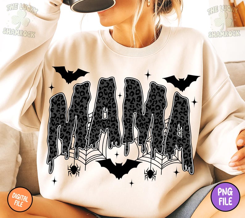 May include: Cream-colored sweatshirt with the word "MAMA" in a dripping, leopard-print design. The design includes bats, spiderwebs, spiders, and stars, creating a Halloween theme. The sweatshirt is a digital file.