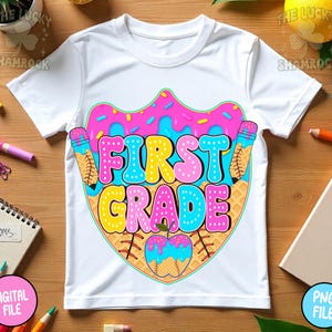 May include: White t-shirt with a colorful graphic design for first grade. The design features the words "FIRST GRADE" in bubble letters, a pink donut, ice cream cones, and a baseball-shaped apple.