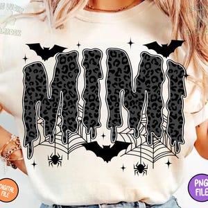 May include: Cream-colored t-shirt featuring the word "MIMI" in a dripping, leopard-print design. The design includes bats, spiderwebs, spiders, and stars, creating a Halloween theme. The shirt also has a "DIGITAL FILE" and "PNG FILE" label.