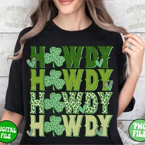 May include: Black t-shirt with a green, white, and yellow graphic design that says "Howdy" four times. Each "Howdy" is decorated with a shamrock design.