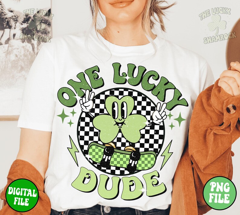 May include: White t-shirt with a green shamrock graphic and the text "One Lucky Dude" in a retro style.