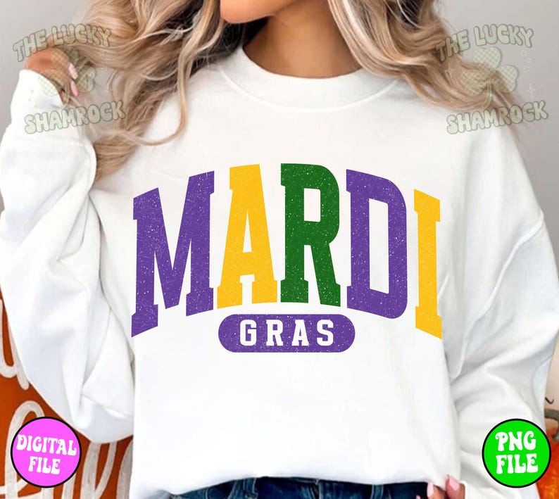 Puede incluir: Sudadera blanca con un gr&aacute;fico morado, verde y amarillo que dice "Mardi Gras".
