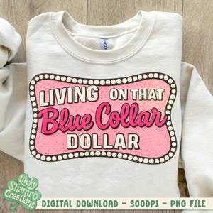 May include: Cream-colored sweatshirt with a pink and white graphic that reads "LIVING ON THAT Blue Collar DOLLAR." The design is framed with a dotted border. The sweatshirt is a digital download.