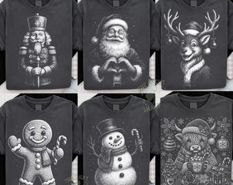 May include: A collection of six charcoal gray t-shirts featuring white illustrative prints of holiday characters including a nutcracker, Santa Claus making a heart shape, a reindeer, a gingerbread person, a snowman, and a highland cow.