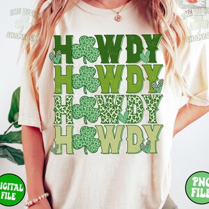 May include: A white t-shirt with the text "Howdy" repeated four times in green, with shamrock designs and a leopard print pattern.