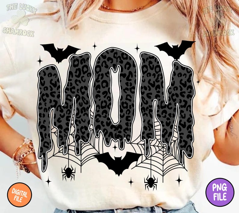 May include: Cream-colored t-shirt featuring the word "MOM" in a dripping, leopard-print design. The design includes bats, spiderwebs, and spiders, with the text "DIGITAL FILE" and "PNG FILE" in the corners. A Halloween-themed graphic.
