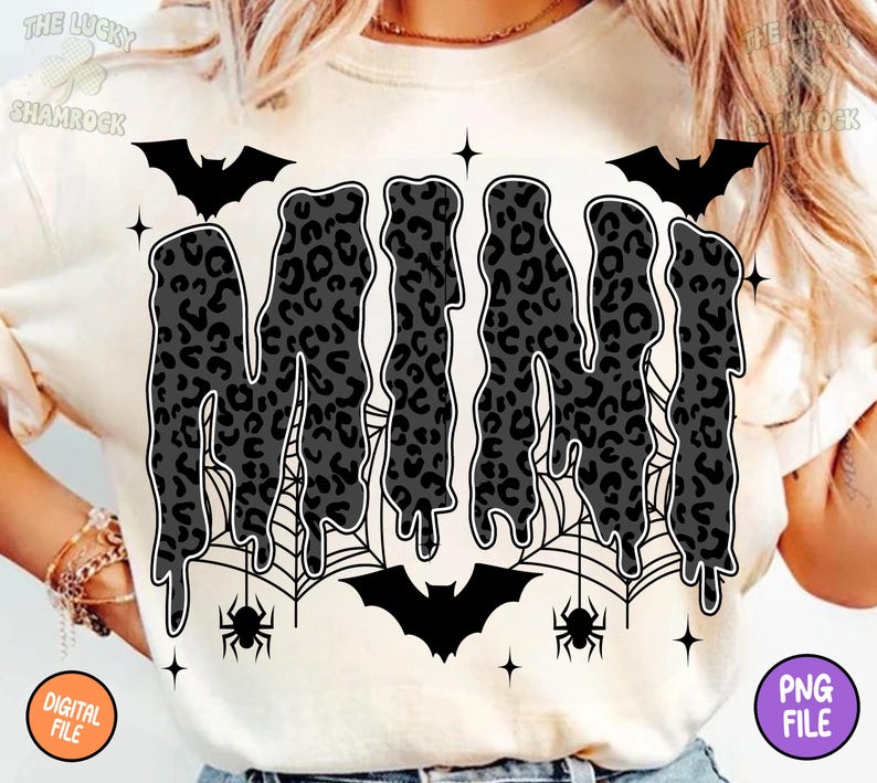 May include: Cream-colored t-shirt with a Halloween-themed design. The word "MINI" is displayed in a dripping font with a leopard print pattern. Bats, spiderwebs, and spiders surround the word, with star accents.