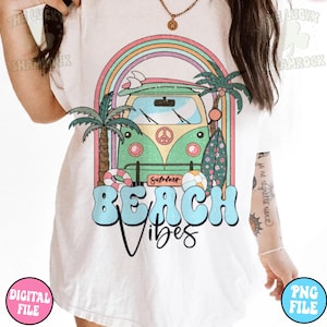 May include: A white t-shirt with a graphic design of a green vintage van with a surfboard on top, palm trees, and a rainbow. The text "Summer" and "Beach Vibes" is printed on the shirt.