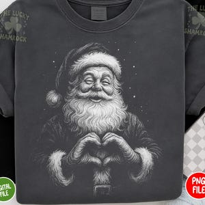 May include: Dark gray t-shirt featuring a detailed illustration of Santa Claus forming a heart shape with his hands. Santa is smiling with his eyes closed, and has a long white beard and hat. The text "The Lucky Shamrock" is printed on the top left and right.