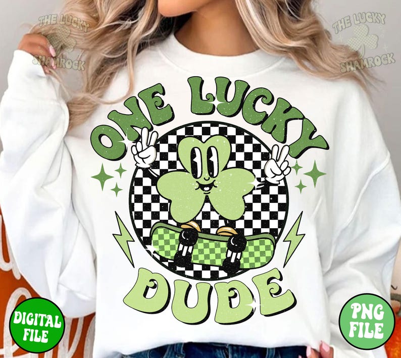 May include: White sweatshirt with a green shamrock character skateboarding and the text "One Lucky Dude" in green letters.