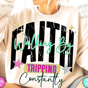 Puede incluir: Sudadera crema con la frase "Faith Walking By Tripping Constantly" en fuente negra desgastada, guion turquesa y detalles rosas y dorados. El dise&ntilde;o incluye estrellas y gr&aacute;ficos de estrellas.