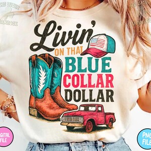 Puede incluir: Camiseta color crema con un dise&ntilde;o gr&aacute;fico que presenta botas de vaquero, una gorra de b&eacute;isbol con una bandera estadounidense y una camioneta roja. El texto dice "Livin' on that Blue Collar Dollar."