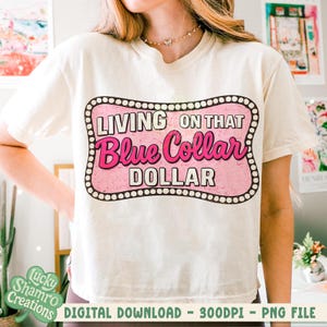 May include: Cream-colored t-shirt with a pink and white graphic that reads "LIVING ON THAT Blue Collar DOLLAR." The design is framed with a dotted border. The shirt is a digital download.