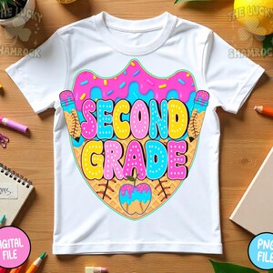 May include: White t-shirt with a colorful graphic design for second grade. The design features the words "SECOND GRADE" in bubble letters, with a donut and ice cream cone theme. The shirt is made of a soft, comfortable material.