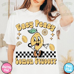 May include: White t-shirt with a yellow lemon cartoon character and the text "Easy Peasy Lemon Squeezy" in a retro style font.