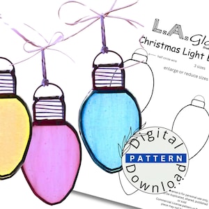 Könnte beinhalten: Drei Weihnachtsbaumschmuck aus Buntglas in Form von Glühbirnen in Rosa, Gelb und Blau. Der Schmuck hängt an einer weißen Schnur mit einer Schleife. Das Bild zeigt eine schwarz-weiße Umrandung des Schmucks mit dem Text "L.A. Glass Christmas Light Bulbs" und "3 Größen, vergrößern oder verkleinern".