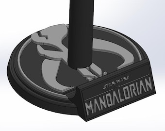 May include: A black and gray base featuring the Mandalorian logo and the text "STAR WARS THE MANDALORIAN." The base has a circular design with a raised edge and a central post.