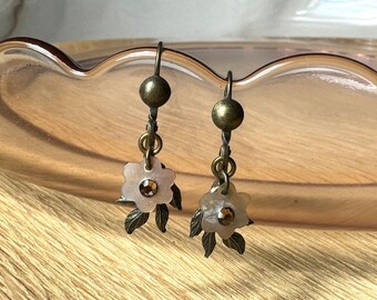 Par de pendientes colgantes de latón antiguo y concha con diseño floral y cierre de palanca con diamantes de imitación rosas.