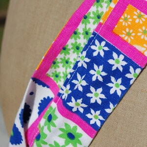 Puede incluir: Primer plano de una tela colorida con un patr&oacute;n floral. La tela es rosa, azul, verde y amarilla. Las flores son blancas con centros verdes.