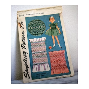 May include: A vintage Simplicity sewing pattern for a smocked dress. The pattern is for a child's dress and includes two smocking designs. The pattern is printed on a blue background with a picture of a girl wearing the dress. The pattern number is 4045 and the price is 23 cents.